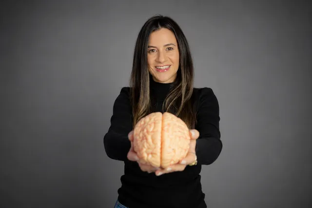 Leilane Verga segurando um modelo anatômico de cérebro